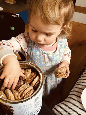 Young girl selecting oatcakes from a KiloCan